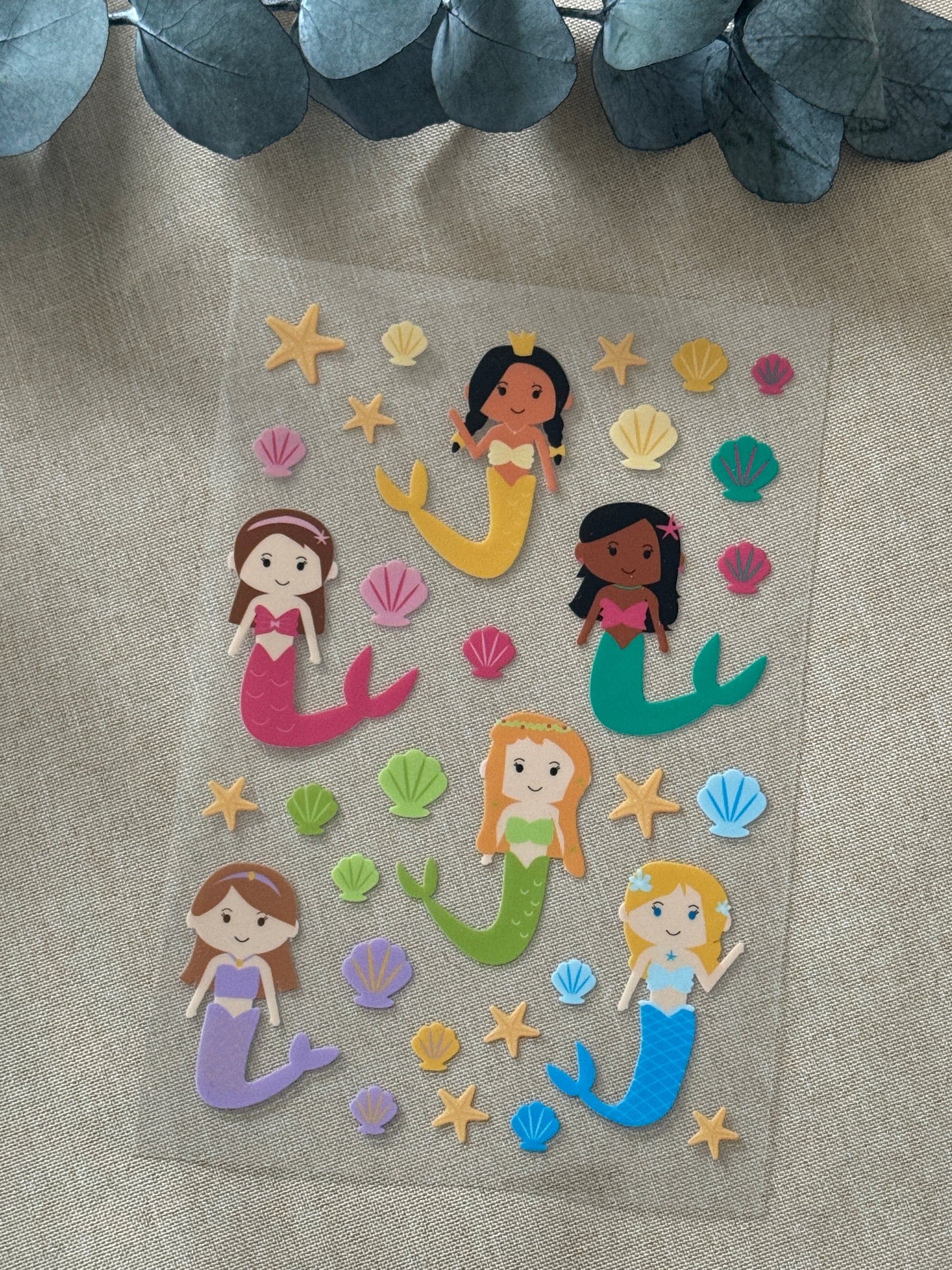 Rub On Aufkleber Meerjungfrauen A5 Warum du unsere Rub-Ons lieben wirst:  ✔ Randloser Premium-Look   ✔ Besondere Haptik   ✔ Präzise Platzierung dank transparenter Trägerfolie  ✔ Wasser- und kratzfest // Hitze- und UV-beständig   ✔ Starke Haftung auf Glas, Keramik, Holz, Raysin u.v.m.  ✔ Langlebig und hochwertig verarbeitet  ✔ Auch gewerblich nutzbar – keine zusätzliche Lizenz nötig